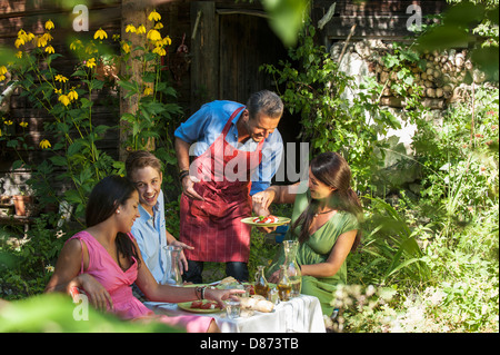 L'Autriche, Pays de Salzbourg, l'homme servant à sa famille dans le jardin Banque D'Images