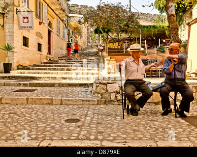 Deux vieux hommes grecs assis sur le banc et parler de la ville de Corfou, Corfou, Grèce Banque D'Images