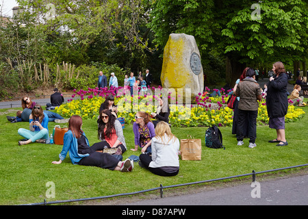 Les jeunes gens s'asseoir et se détendre sur une journée ensoleillée à St Stephen's Green Park, Dublin, République d'Irlande Banque D'Images
