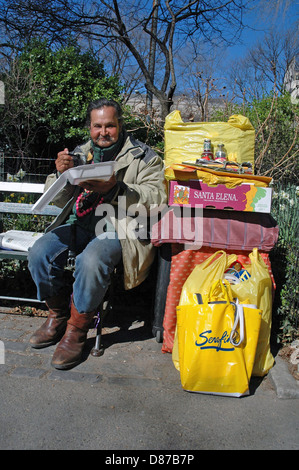 Sans-abri à New York assis sur un banc de manger des repas à emporter. Banque D'Images