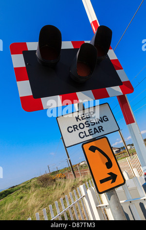 Des panneaux d'avertissement. feux de circulation et d'urgence téléphone à côté d'un passage à niveau, près d'Irvine, Ayrshire, Scotland Banque D'Images