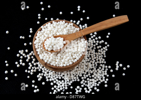 Perles de tapioca en petit bois bol sur fond noir Banque D'Images