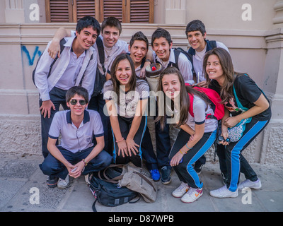 Un groupe d'étudiants de l'école des adolescentes, les garçons et filles, sourire & faire face à l'avant, étant donné qu'ils recueillent à l'extérieur de leur école à Asunción. Banque D'Images