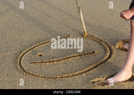 Un sourire s'appuyant sur un sable. Banque D'Images