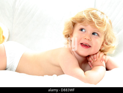 À Angélique jeune garçon avec les cheveux bouclés blonds sur fond blanc Banque D'Images