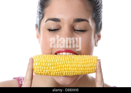 Heureux sain Woman eating fresh Ripe le maïs doux en épis et seul contre un arrière-plan uni, Blanc seulement Banque D'Images