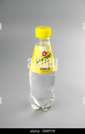 La marque Schweppes tonic transparent petite bouteille d'eau en plaine lumière normale sur un fond gris. Banque D'Images