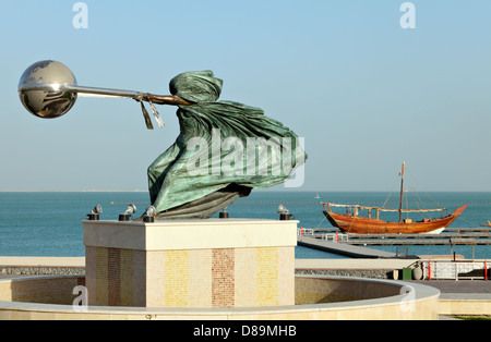 La force de la nature II par Lorenzo Quinn, exposée au village du patrimoine de Katara, Doha, Qatar, avec un boutre arabe derrière elle Banque D'Images