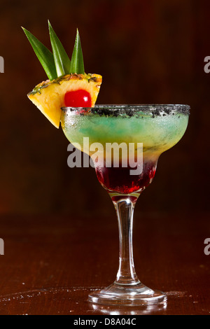 Belle tropical cocktail servi dans un verre à margarita sel noir sur la jante et une tranche d'ananas avec une cerise dans c Banque D'Images