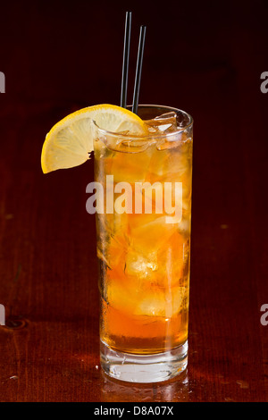 Cocktail classique long island iced tea servi sur un bar et garni d'une tranche de citron Banque D'Images