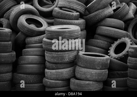 Vieux pneus empilés avec des piles Banque D'Images