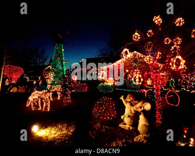 Une cour décorée avec des lumières de Noël et diverses décorations de vacances. L'exposition comprend des arbres illuminés, des ornements festifs et une atmosphère de vacances joyeuse. Banque D'Images