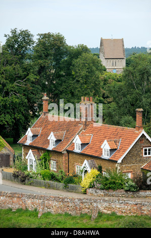 Cottages en brique rouge avec des lucarnes et des jardins et l'église de Saint-Laurent au village de Castle Rising, Norfolk, Angleterre Banque D'Images