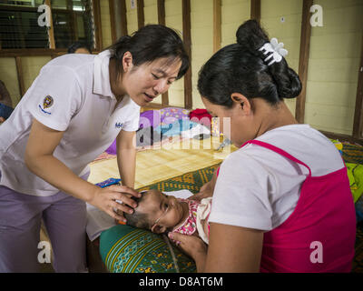 21 mai 2013 - Mae Ku, Tak, Thaïlande - CINDY CHU, un médecin américain, des chèques sur un bébé Birman à la Maw Ker clinique thaïlandaise de Mae Ku. Il y a plus de deux millions de réfugiés et migrants birmans en Thaïlande et l'écrasante majorité n'ont pas accès à des services sociaux thaïlandais il doit utiliser les services fournis par les ONG. Le Wangpha clinique est dirigé par l'Shaklo la Malaria Research Unit (SMRU), qui exploite des collectes le long de la frontière thaïlando-birmane (Myanmar) dans la province de Tak. (Crédit Image : © Jack Kurtz/ZUMAPRESS.com) Banque D'Images