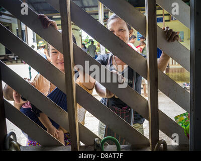 21 mai 2013 - Mae Ku, Tak, Thaïlande - Burmese patients en attente pour voir un médecin de regarder à travers un mur à lattes à la Maw Ker clinique thaïlandaise de Mae Ku. Il y a plus de deux millions de réfugiés et migrants birmans en Thaïlande et l'écrasante majorité n'ont pas accès à des services sociaux thaïlandais il doit utiliser les services fournis par les ONG. Le Wangpha clinique est dirigé par l'Shaklo la Malaria Research Unit (SMRU), qui exploite des collectes le long de la frontière thaïlando-birmane (Myanmar) dans la province de Tak. (Crédit Image : © Jack Kurtz/ZUMAPRESS.com) Banque D'Images