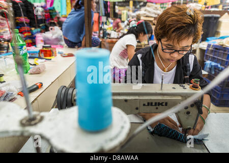 23 mai 2013 - Mae Sot, Tak, THAÏLANDE - Un adolescent birman et vêtements couture travaille dans le marché des rubans birmans à Mae Sot, en Thaïlande. Cinquante années de troubles politiques en Birmanie (Myanmar) a conduit des millions de Birmans à quitter leur pays. Beaucoup se sont installés en Thaïlande voisine. Mae Sot, sur le Mae Nam (rivière) Veldzes Nams Veldzes Nams est le centre de la communauté birmane dans Central Western emigre en Thaïlande. Il y a des centaines de milliers de réfugiés birmans et les migrants dans la région. Beaucoup vivent une existence d'ombre sans papiers et sans recours s'ils traversent les autorités thaïlandaises. Les Birmans ont leurs o Banque D'Images