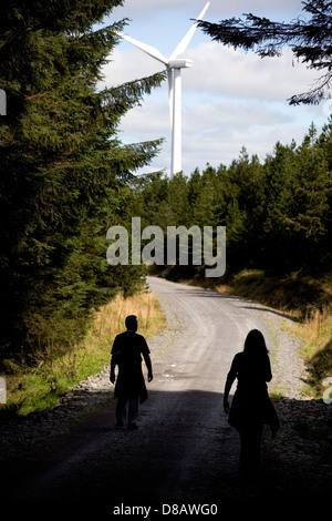 Les randonneurs en Pays de Galles à marcher le long d'un sentier vers une éolienne. Banque D'Images