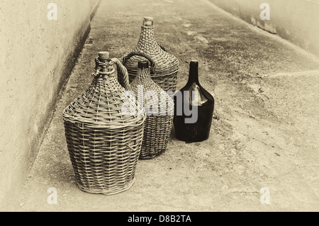 Des bouteilles de vin en osier tissé. Image en noir et blanc comme carte postale vintage stylisée. Banque D'Images