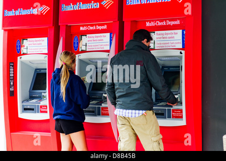 Jeune homme et jeune femme obtenir de l'argent d'une banque ATM. Banque D'Images