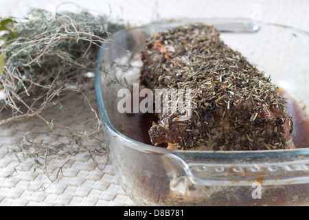 Porc au four avec des herbes dans un plat transparentes provinciaux Banque D'Images