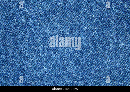 Une vue rapprochée du tissu denim bleu, soulignant sa texture et son tissage. Le denim est un tissu de coton durable souvent utilisé dans les jeans, les vestes et autres vêtements. Le tissage et la texture le rendent facilement reconnaissable et un choix populaire pour les vêtements décontractés. Banque D'Images