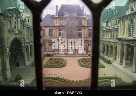 Paris, France. Les beaux jardins de Musée Carnavalet, le musée de l'histoire de Paris, vue à travers le verre coloré. Banque D'Images