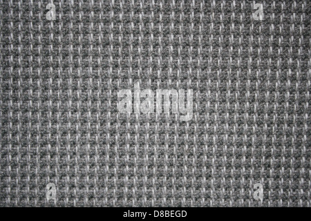 Cette image montre la texture en gros plan du tissu d'ameublement gris, mettant en valeur un matériau doux et tissé couramment utilisé dans les meubles et la décoration intérieure. Le tissu présente un ton gris neutre, adapté à divers styles de design d'intérieur. Il reflète la durabilité et le confort, ce qui le rend idéal pour les canapés, chaises et autres meubles rembourrés. La texture du tissu offre une vue claire de son tissage et de sa composition. Banque D'Images