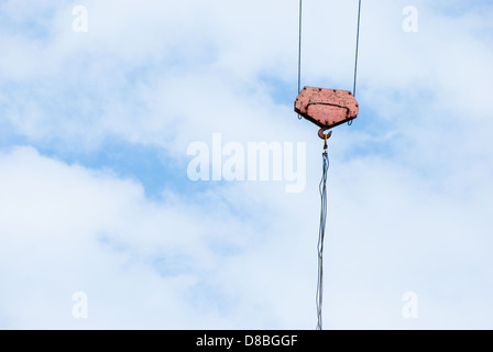 Crochet de grue avec corde rouge sur bleu ciel nuageux Banque D'Images