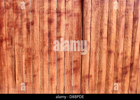 Gros plan d'une clôture en bois teinté, mettant en valeur sa texture altérée et sa couleur riche et profonde. L'image met en valeur le grain du bois et la tache protectrice, améliorant l'aspect naturel du bois. Banque D'Images