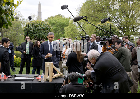 Le président américain Barack Obama ressemble à un morceau d'un carburant de substitution au bois fabriqué à partir de déchets de biomasse tandis que les projets présentés à la Maison Blanche Expo-sciences dans le jardin de l'Est de la Maison Blanche le 22 avril 2013 à Washington, DC. Jon, Kubricki Zarych, gauche et Bridget, centre, de Pinelands Eco Regional High School à Little Egg Harbor, New Jersey), ont présenté leurs mini-presse qui transforme les déchets de biomasse bois-alternative viable en combustible pour la cuisine. Banque D'Images