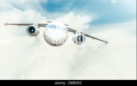 Avion du passager avec cockpit et des moteurs en vue de face de haut vol en bleu ciel nuageux. Rapide et confortable qui voyagent par avion. Banque D'Images