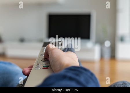 En poussant la touche sur la télécommande pour home cinéma Banque D'Images