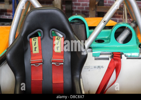 Cockpit avec un seul siège et ceinture rouge dans une vieille voiture de course Banque D'Images