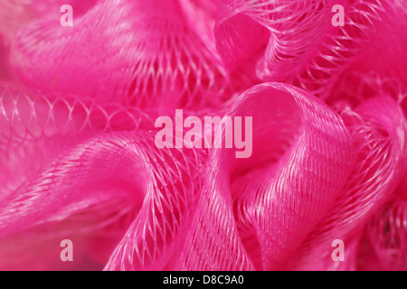 Macro d'une baignoire ou d'une éponge rose puff, détail filet de plastique, la texture de fond. Banque D'Images