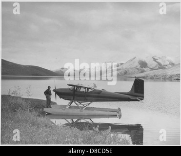 Un hydravion Cessna de 180, conçu pour les atterrissages et les décollages, se trouve à la surface d'un lac. L'avion est reconnu pour sa robustesse et sa polyvalence dans les environnements aéronautiques et aquatiques. Banque D'Images
