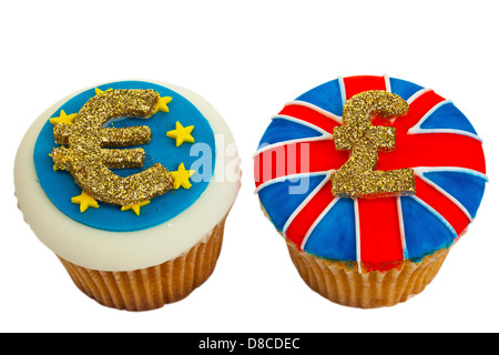 Deux petits gâteaux glacés décorées avec Euro et Sterling signes et drapeaux. Banque D'Images