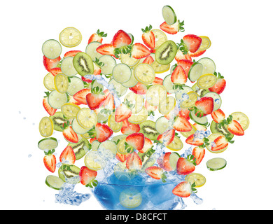 Tranches de fruits assortis tomber dans le verre rempli de glace et d'eau. Isolé sur fond blanc. Banque D'Images