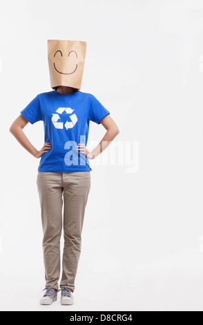 Jeune femme avec smiley face sac de papier sur la tête Banque D'Images