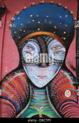 Close up sur fresque de femmes avec quatre yeux contre un fond rose Banque D'Images