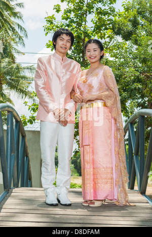 Thai asiatique suite nuptiale en costume de mariage thaï est debout au milieu de blue bridge. Banque D'Images