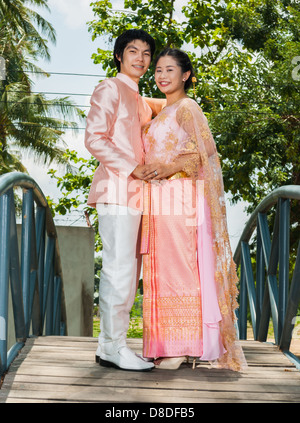 Thai asiatique mariée est embrassant son époux au milieu de blue bridge avec l'amour sentiment. Banque D'Images