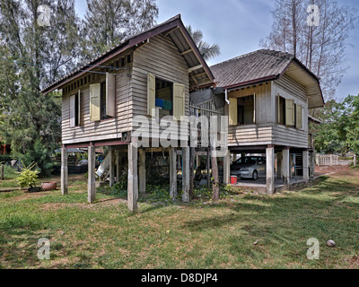 Thai traditionnelle maison en bois sur pilotis avec voiture garée en bas. S. E. Asie Thaïlande Banque D'Images