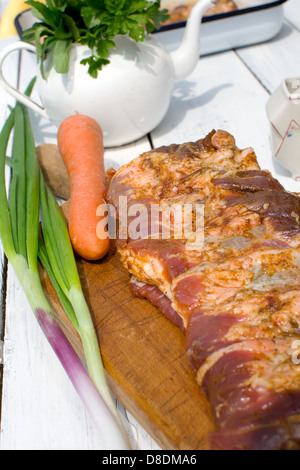 Côtes de porc cru assaisonné pour la cuisson sur une planche en bois Banque D'Images