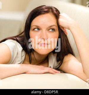 Penser pensive woman lying on sofa in living room Banque D'Images