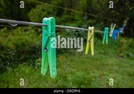 En plastique coloré pegs hanging sur ligne de lavage Banque D'Images