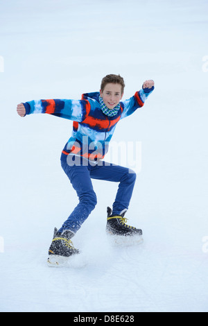 Boy le patin à glace sur un lac gelé Banque D'Images