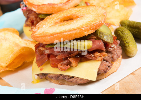 L'artère-colmatage Luther Burger : un boeuf patty, fromage, bacon croustillant et cornichons entre deux moitiés d'une bague émaillée donut. Banque D'Images