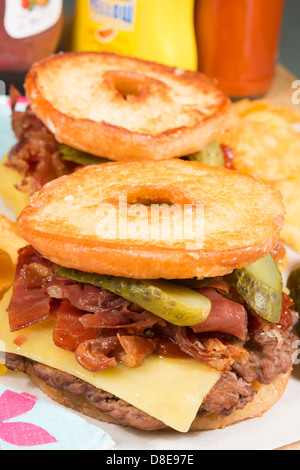 Le Luther Burger : un boeuf patty, fromage, bacon croustillant et cornichons entre deux moitiés d'une bague émaillée donut. Banque D'Images