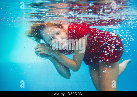L'imagination, l'underwater portrait de femme en robe rouge Banque D'Images