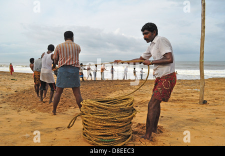 Les pêcheurs travaillant sur la plage Banque D'Images